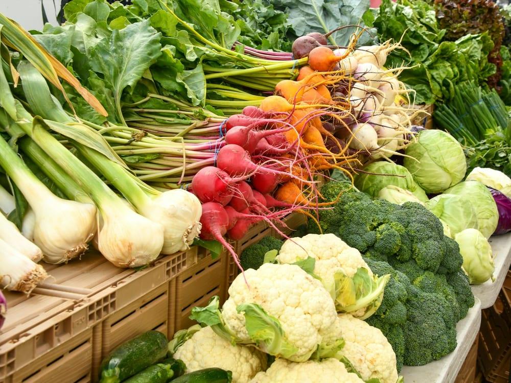 Banca de feira com couve-flor, rabanete, cebola e brócolis